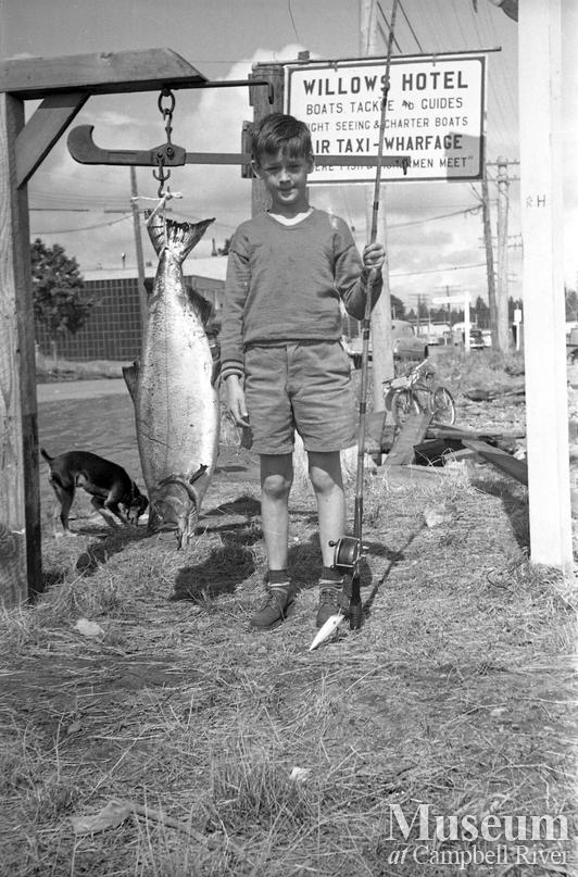 Unidentified child with a salmon at the Willows Hotel