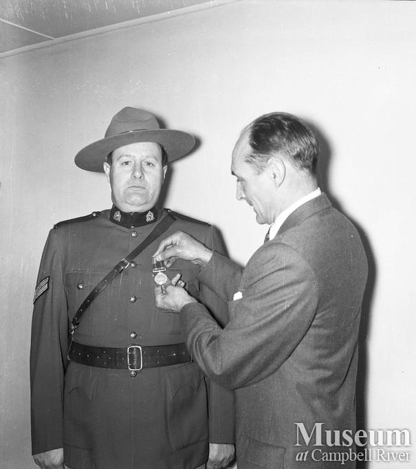 Police officer receiving an award from Judge Roderick Haig-Brown