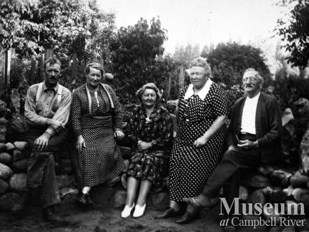 Group sitting on Rock garden in Petersen family's front yard, Campbellton