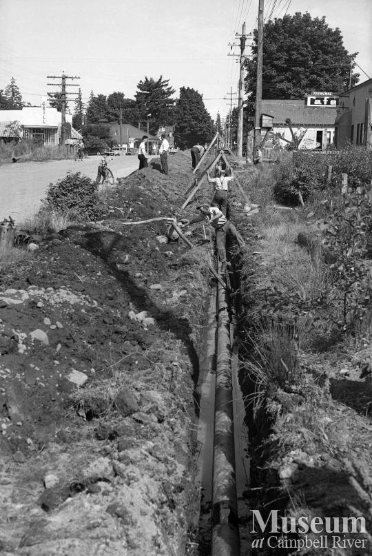 Installing the waterline along the Island Hwy at Campbellton