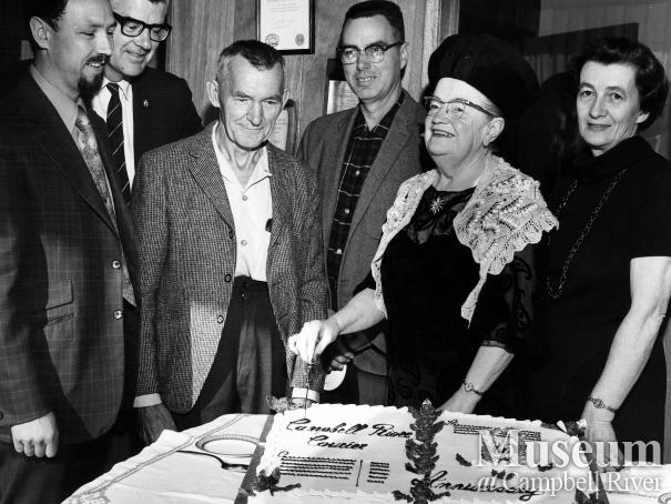 Lillie Thulin cuts cake to commemorate anniversary, 1971.
